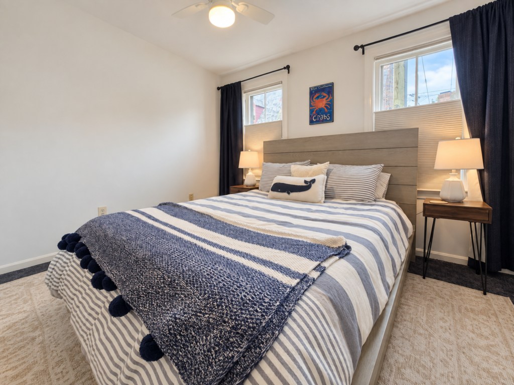 Blue-and-white bedroom with a wood headboard.

