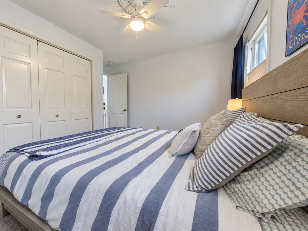 Bedroom with paneled closet doors and layered bedding.
