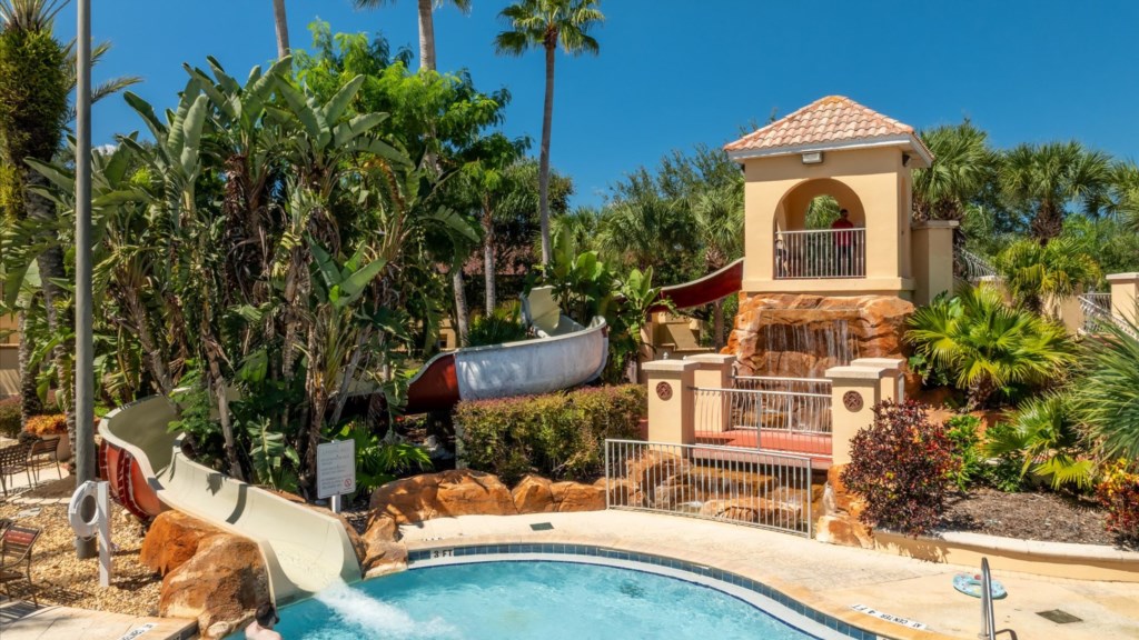 Water Slide & Splash Area
Exciting water slide with rock waterfall features, leading into the pool, ideal for kids.