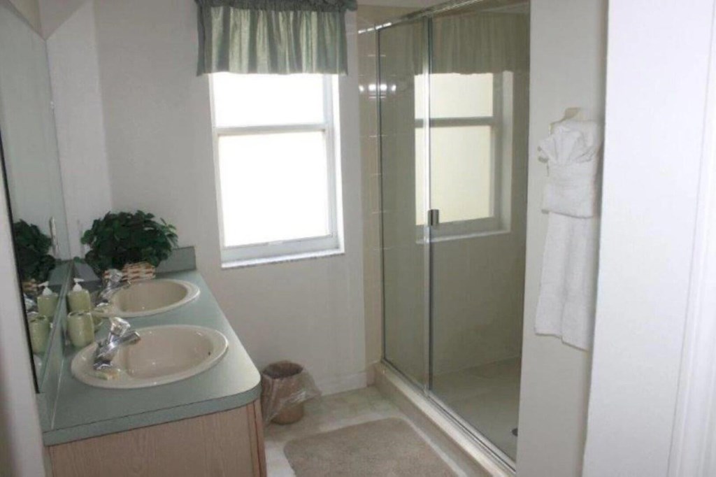 The secondary en-suite bathroom is equipped with a double vanity and a spacious walk in shower