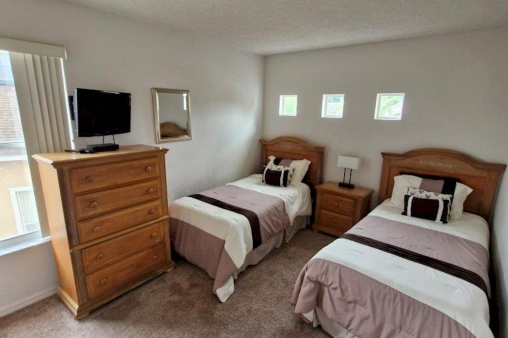 This serene twin bedroom features comfortable bedding and a spacious closet, perfect for a relaxing stay