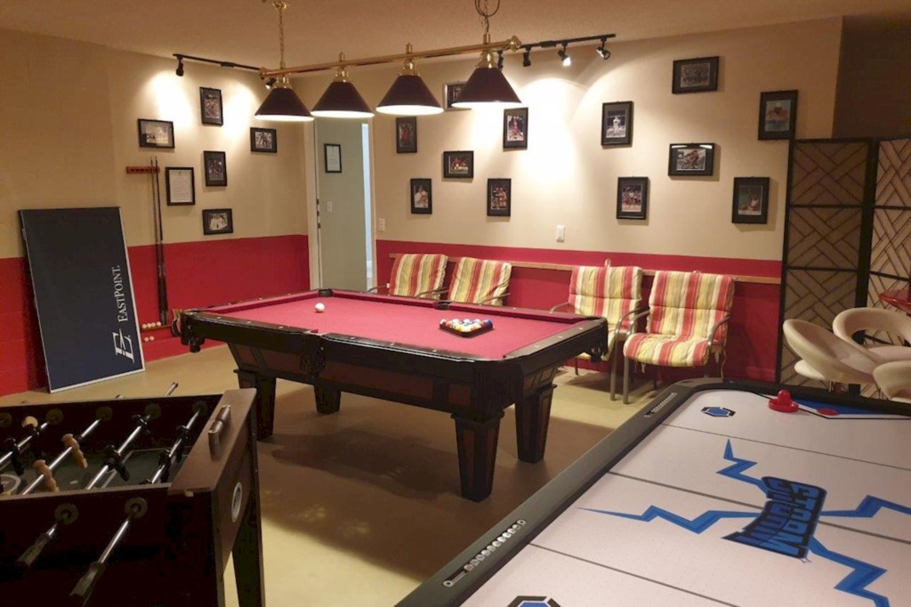  This spacious game room is the ultimate entertainment hub, featuring a pool table, air Hockey table and comfy seating