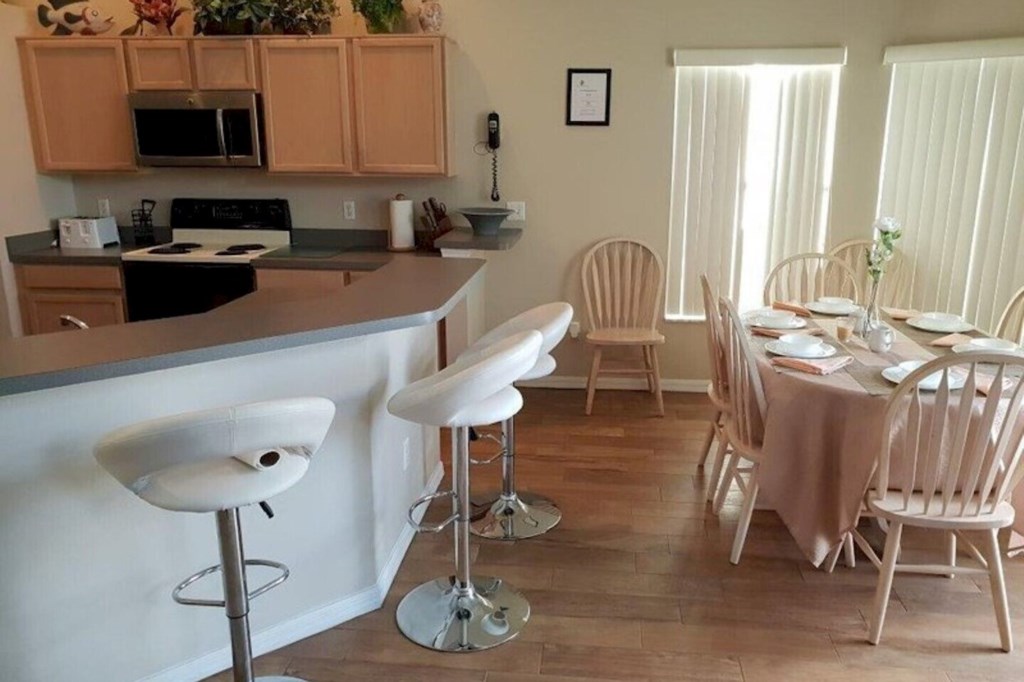 Spacious kitchen and dining area featuring a breakfast bar with comfortable stools, perfect for casual meals and coffee