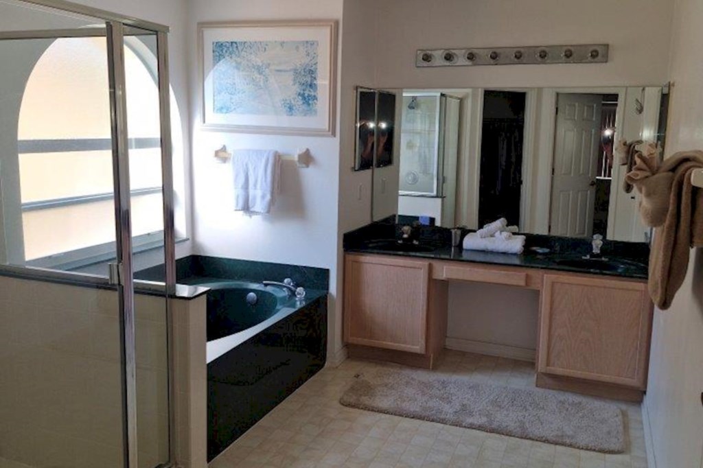 This spacious primary bathroom features a double vanity, a luxurious soaking tub