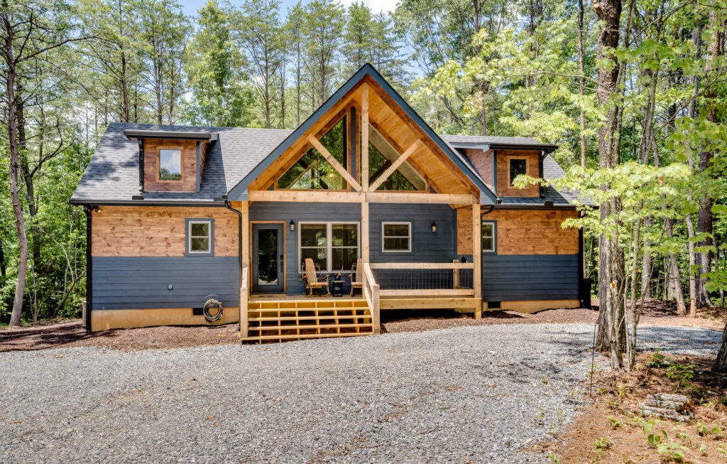 Charming cabin retreat nestled in the woods with a cozy front porch for relaxing.