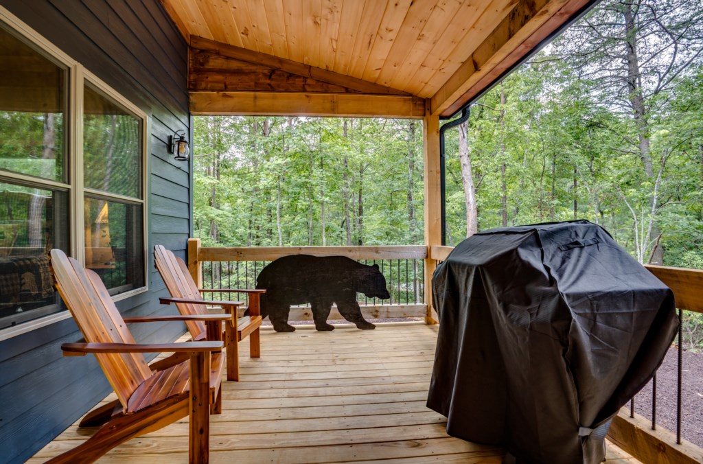 Charming deck with Adirondack chairs and grill, perfect for enjoying the forest views.