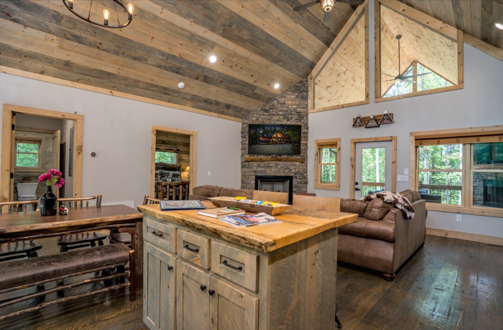 Rustic living area with stone fireplace and vaulted ceilings, perfect for cozy gatherings.