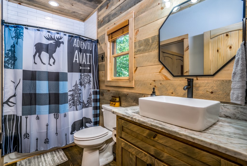 Rustic bathroom with wood accents and adventure-themed decor.
