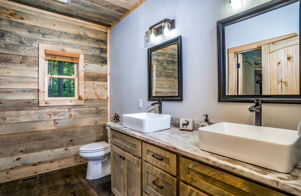 Rustic bathroom with dual sinks and natural wood accents for a cozy cabin feel.