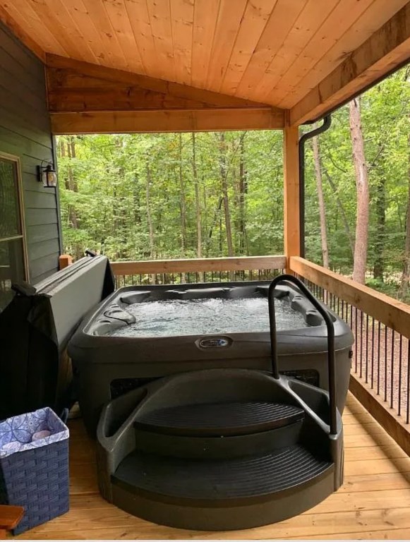 Relax in the private hot tub with serene forest views on the covered deck.