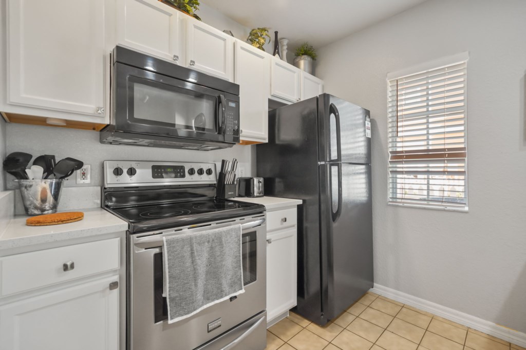 Kitchen area with microwave, stove, fridge, & all you will need for your cooking needs.