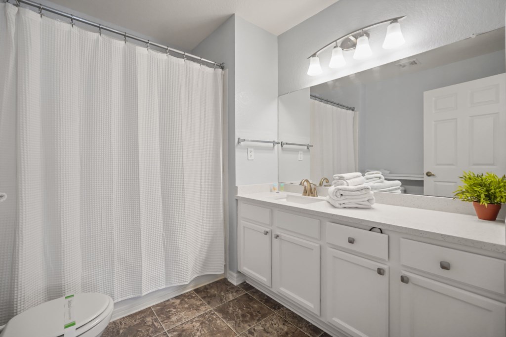 Bathroom # 1 downstairs en-suite to bedroom # 1 with sink, toilet, & tub/shower combo.