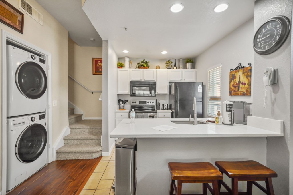 Kitchen area, laundry area, & the stairs leading upstairs.