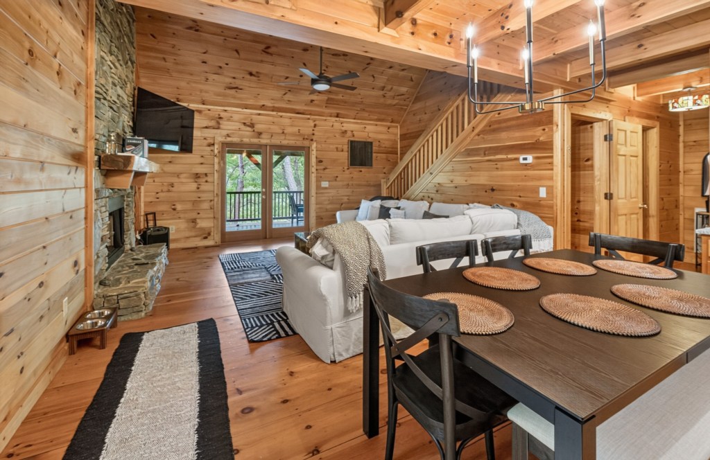 Cozy cabin living area with stone fireplace and dining table, perfect for family gatherings.