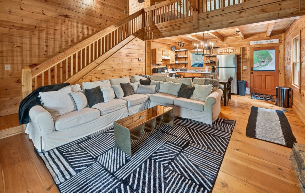 Rustic open-plan living area with cozy seating and modern kitchen, perfect for family gatherings.