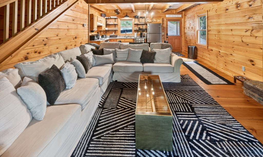 Cozy living area with a plush sectional and rustic wood accents, perfect for relaxing evenings.