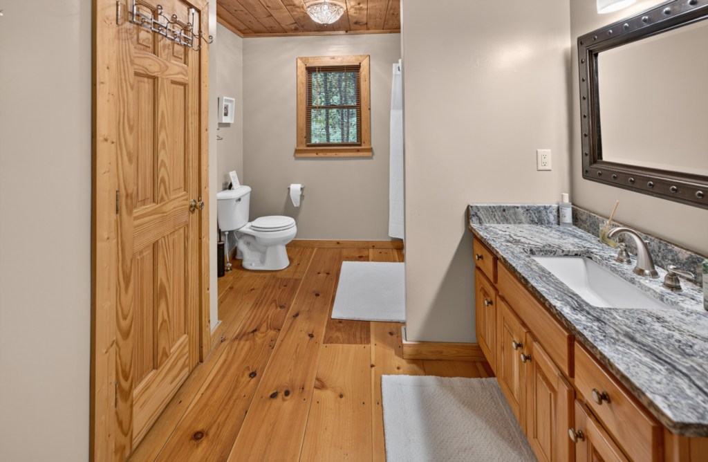 Rustic bathroom with granite countertop and natural wood accents for a cozy cabin feel.