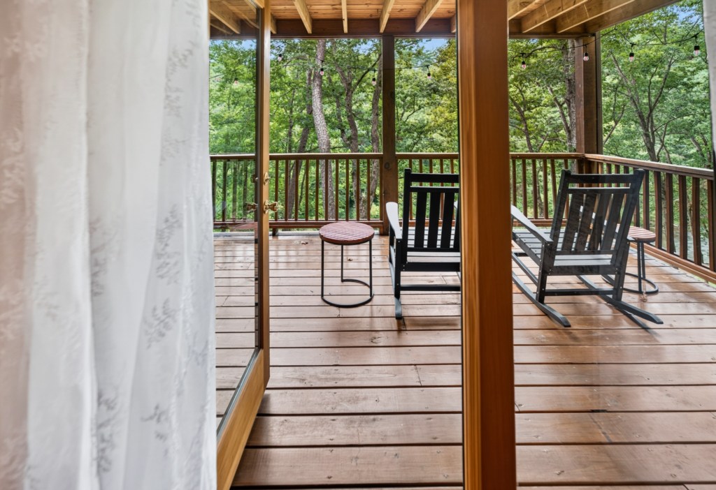 Relax on the private deck with rocking chairs and enjoy serene forest views.