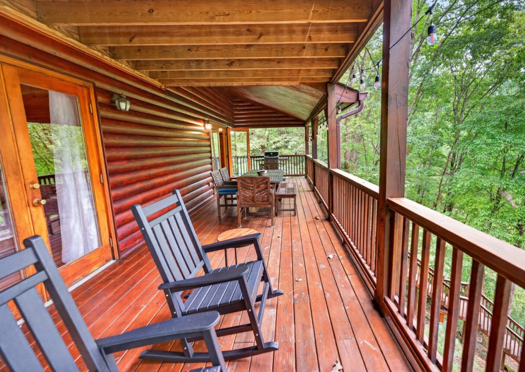 Charming wooden deck with rocking chairs and forest views, perfect for relaxing evenings.