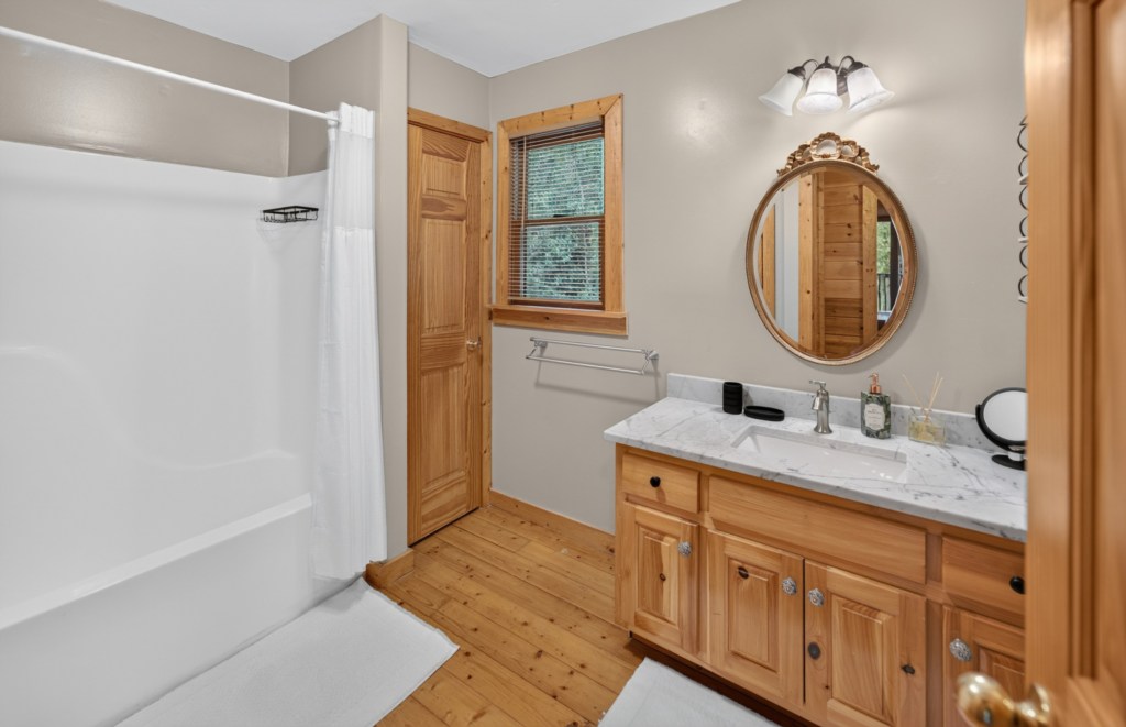 Charming bathroom with rustic wood accents and a spacious shower.