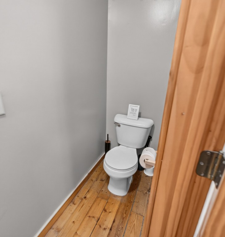 Compact bathroom with modern fixtures and wooden flooring.