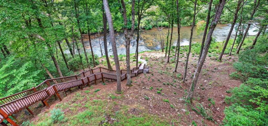 Scenic riverside path with wooden steps, perfect for nature walks and peaceful retreats.