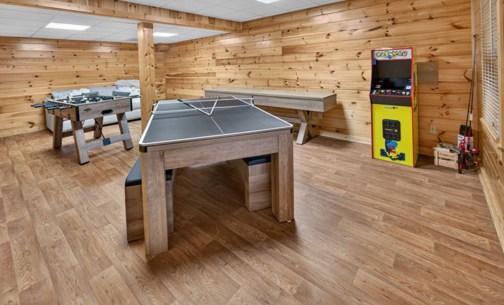 Fun-filled game room with ping pong, foosball, shuffleboard, and arcade machine.