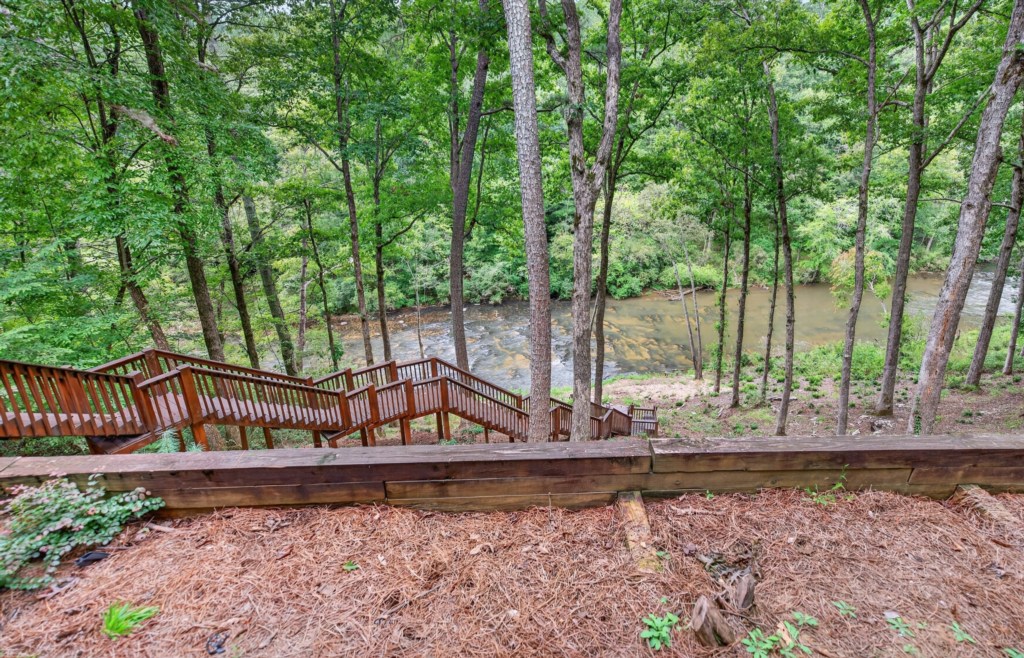 Scenic wooden stairway leading to a tranquil riverside retreat.