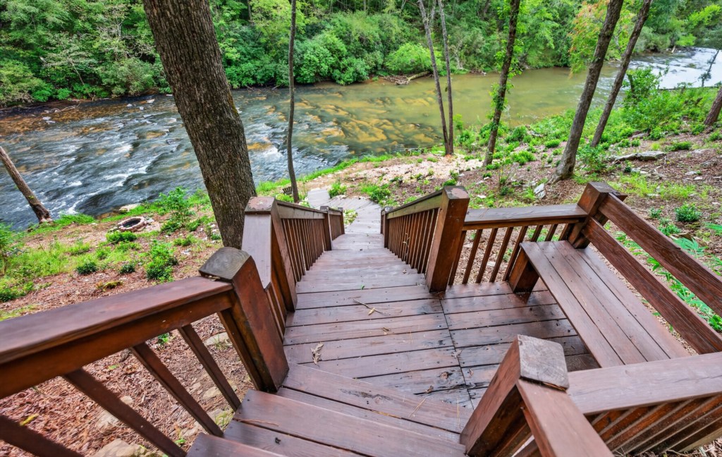 Private wooden staircase leading to a serene riverside retreat.
