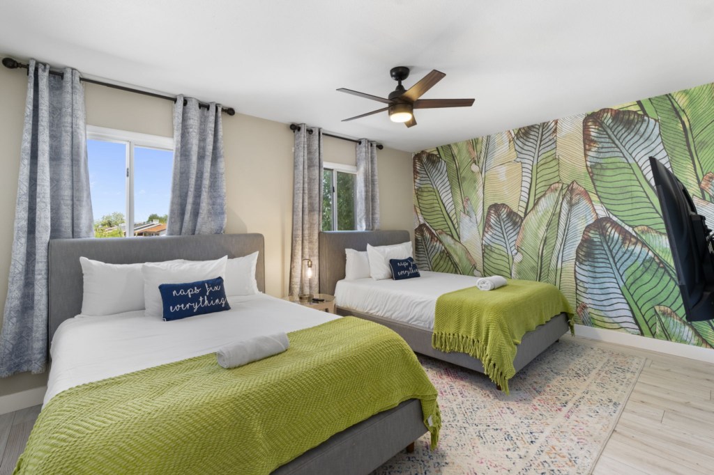 Tropical-themed bedroom with two cozy beds and vibrant decor.