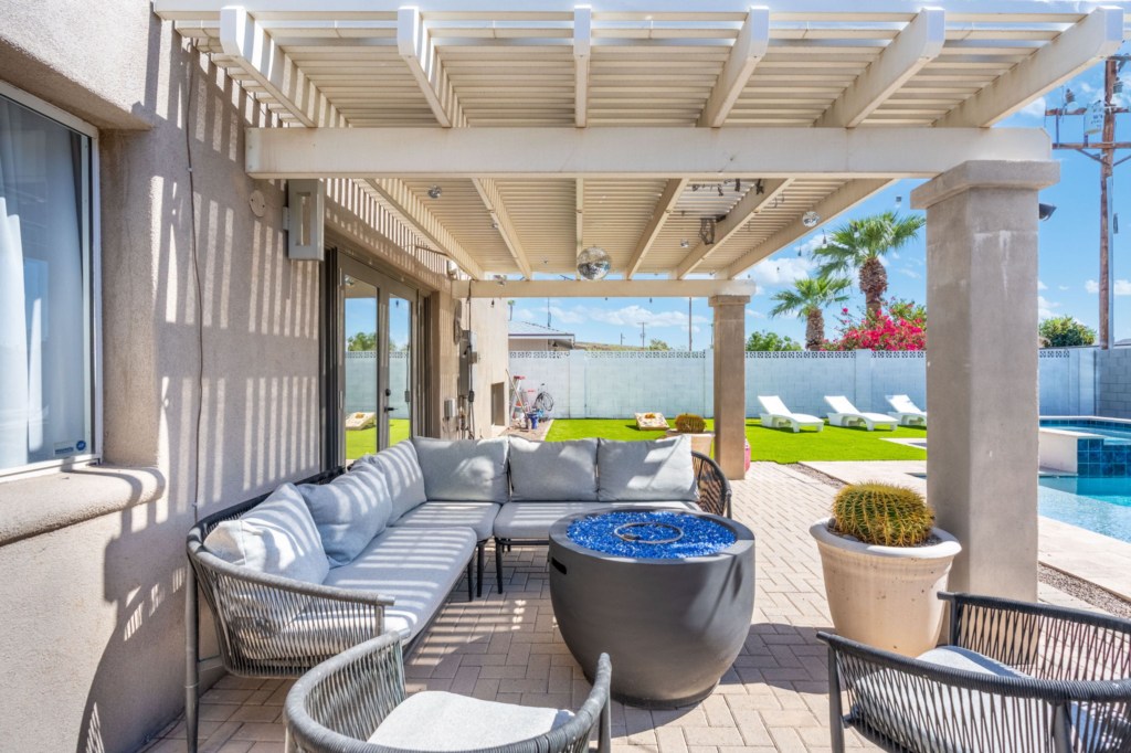 Relax on the shaded patio with a cozy fire pit and poolside views.