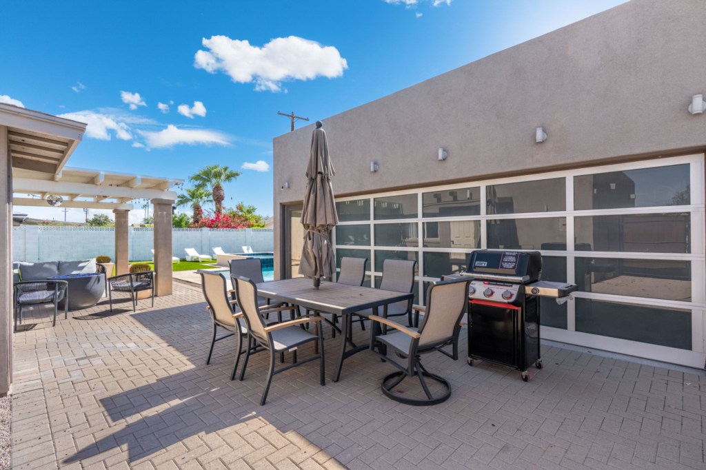 Spacious patio with dining set and BBQ grill, perfect for outdoor gatherings.