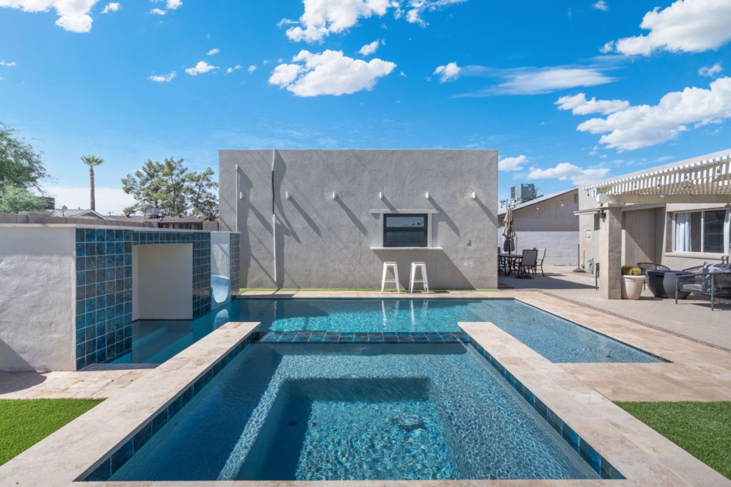 Modern pool area with swim-up bar and ample seating for relaxation.