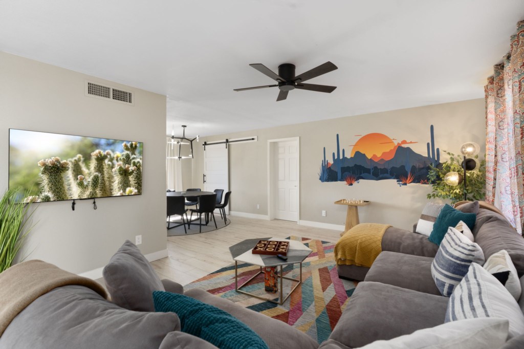 Stylish living room with desert mural and comfy sectional for relaxing.
